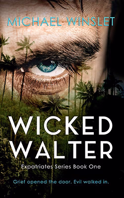 Image of a menacing looking man staring through plam trees.